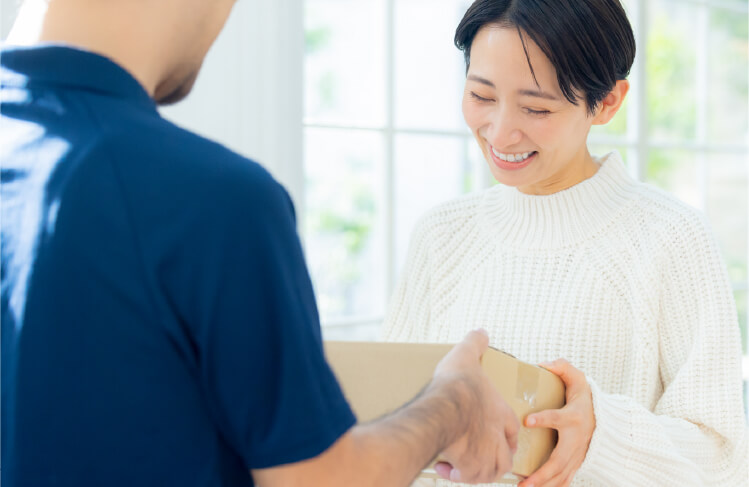 配送員から荷物を受け取る女性
